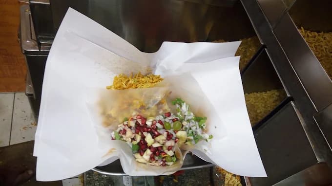 Fresh TamTam being assembled with sev and toppings